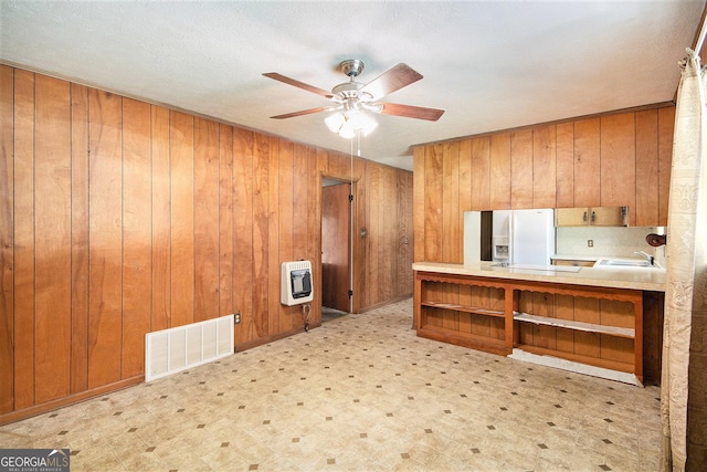 1228 Old Rockmart Rd SE, Silver Creek, GA 30173 - kitchen with heating unit, light floors, open shelves, brown cabinetry, and wood walls