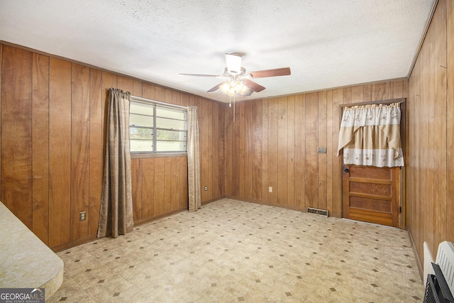 1228 Old Rockmart Rd SE, Silver Creek, GA 30173 - spare room with a ceiling fan, wood walls, heating unit, and a textured ceiling