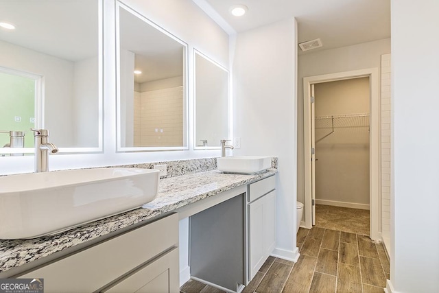 188 Weldon Rd Unit 23, Mcdonough, GA 30253 - full bath with double vanity, toilet, wood tiled floors, a walk in closet, and recessed lighting