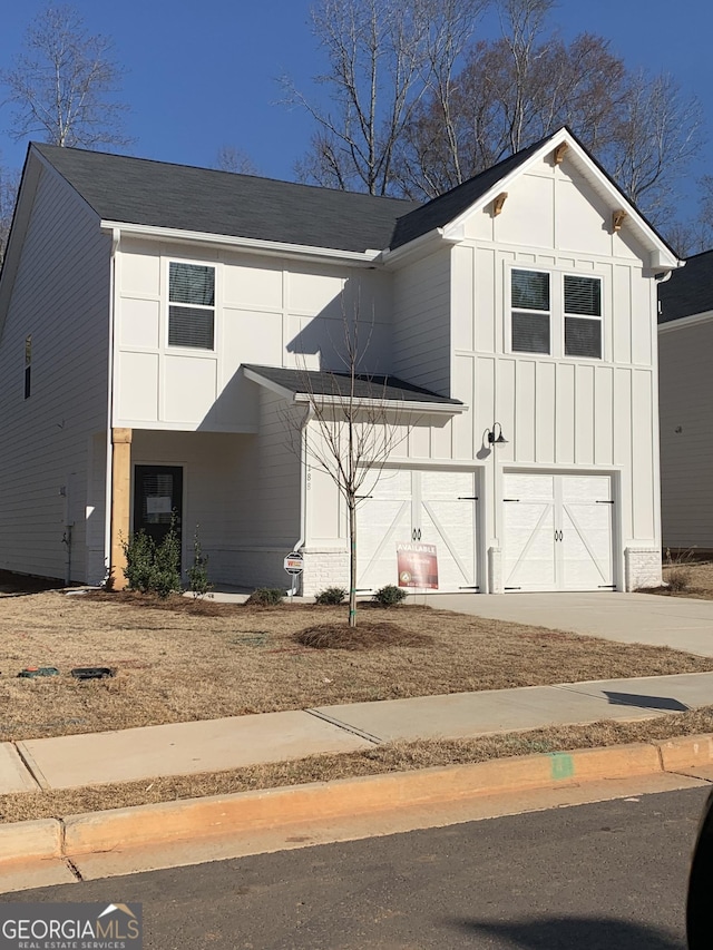 modern inspired farmhouse featuring an attached garage, driveway, and board and batten siding