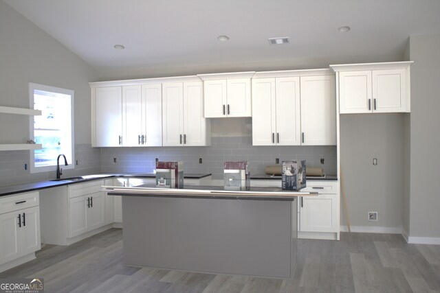 kitchen with vaulted ceiling and white cabinetry