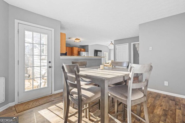 dining area with hardwood / wood-style flooring and ceiling fan