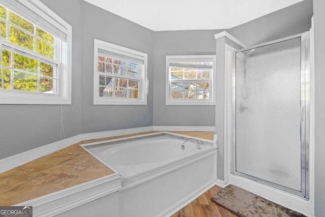 bathroom featuring hardwood / wood-style floors and shower with separate bathtub