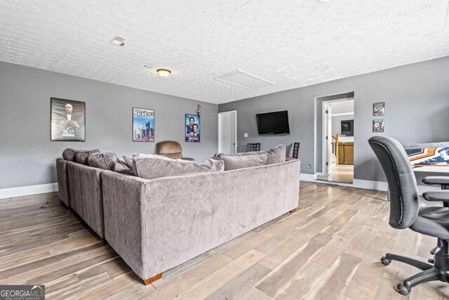 living room featuring a textured ceiling and light wood-type flooring