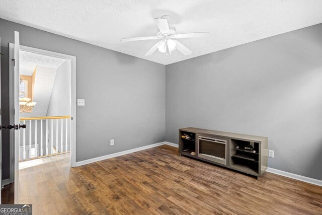 spare room featuring ceiling fan, wood-type flooring, and a textured ceiling