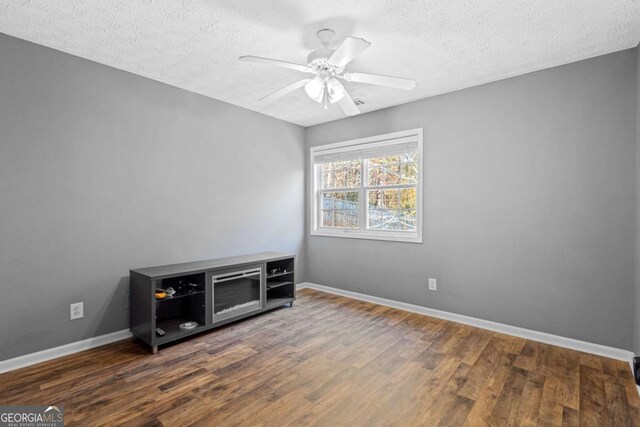 unfurnished room featuring a textured ceiling, dark hardwood / wood-style flooring, and ceiling fan