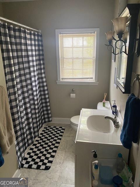 bathroom featuring vanity, curtained shower, and toilet