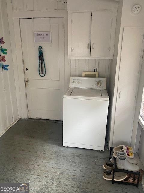 clothes washing area with cabinets, dark hardwood / wood-style flooring, and washer / clothes dryer