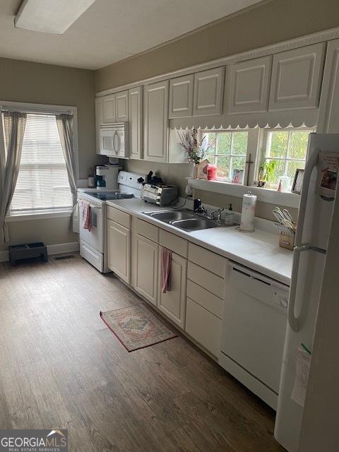 kitchen with light hardwood / wood-style floors, white appliances, sink, and white cabinetry