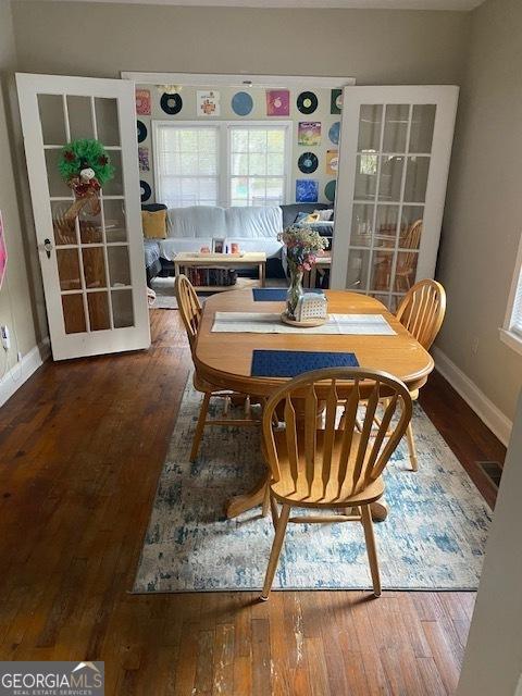 dining space featuring wood-type flooring and french doors