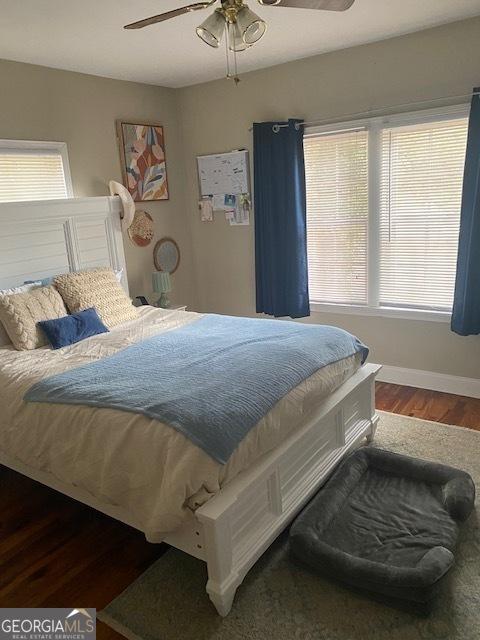 bedroom with dark hardwood / wood-style floors and ceiling fan