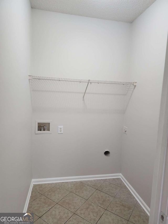 clothes washing area featuring electric dryer hookup, tile patterned flooring, washer hookup, and a textured ceiling