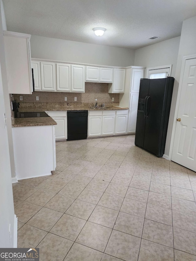 kitchen with decorative backsplash, white cabinetry, light tile patterned floors, and black appliances