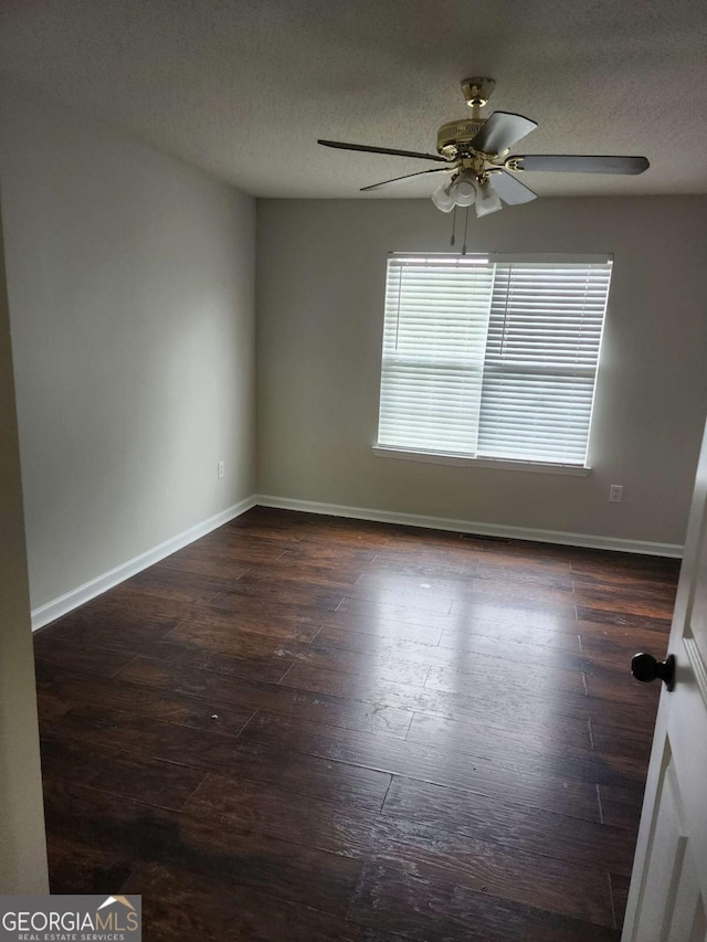 unfurnished room featuring ceiling fan, dark hardwood / wood-style flooring, and a textured ceiling