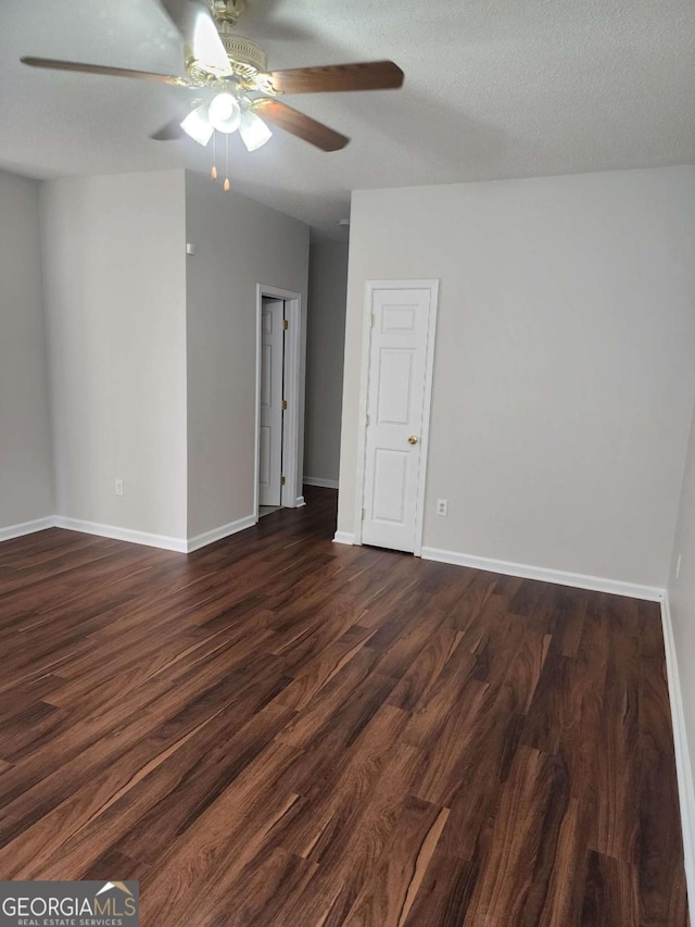 empty room featuring ceiling fan, dark hardwood / wood-style flooring, and a textured ceiling