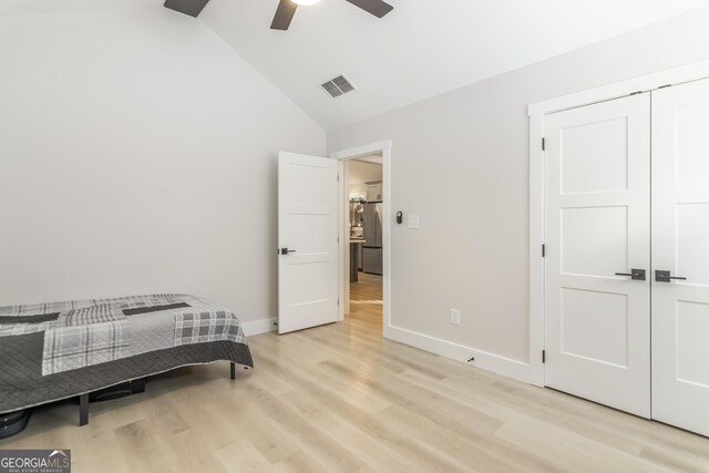 bedroom featuring light hardwood / wood-style flooring and lofted ceiling