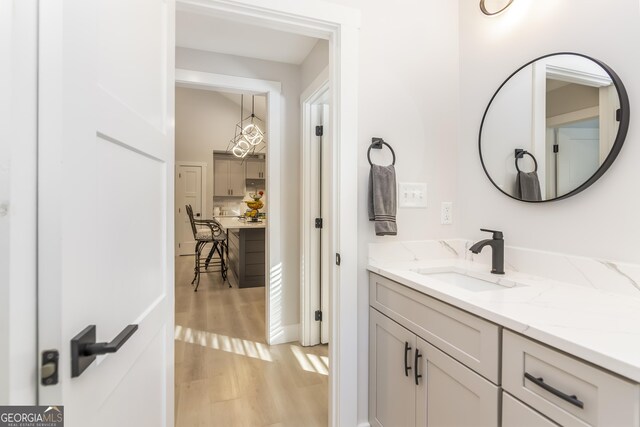 laundry room with cabinets, light wood-type flooring, sink, and washing machine and clothes dryer