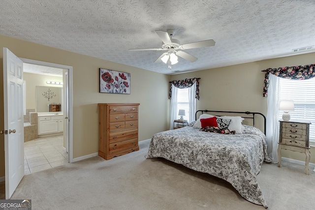 carpeted bedroom featuring a textured ceiling, connected bathroom, and ceiling fan