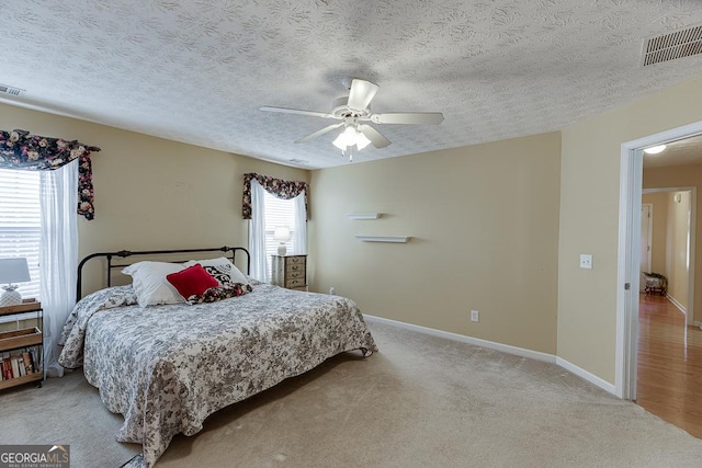 carpeted bedroom with a textured ceiling and ceiling fan