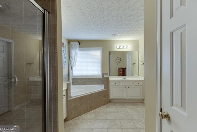 bathroom with tile patterned flooring, a textured ceiling, vanity, and independent shower and bath