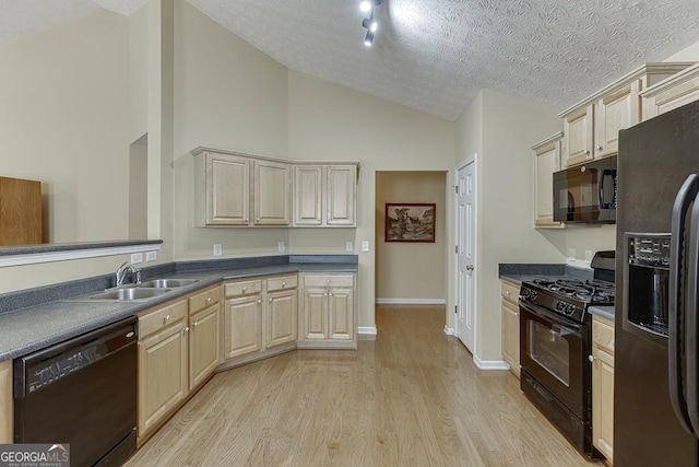 kitchen featuring black appliances, light wood-type flooring, sink, and a textured ceiling