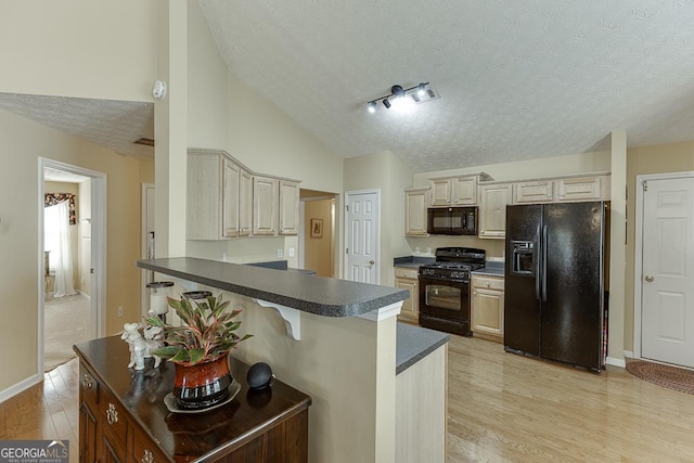 kitchen with a breakfast bar, black appliances, light hardwood / wood-style flooring, a textured ceiling, and kitchen peninsula