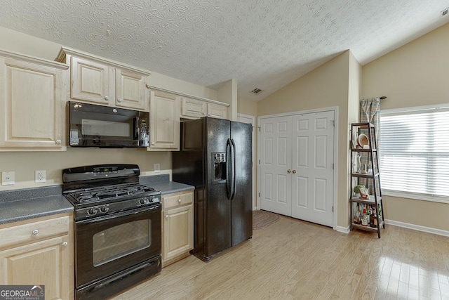 kitchen with a textured ceiling, light hardwood / wood-style floors, lofted ceiling, and black appliances