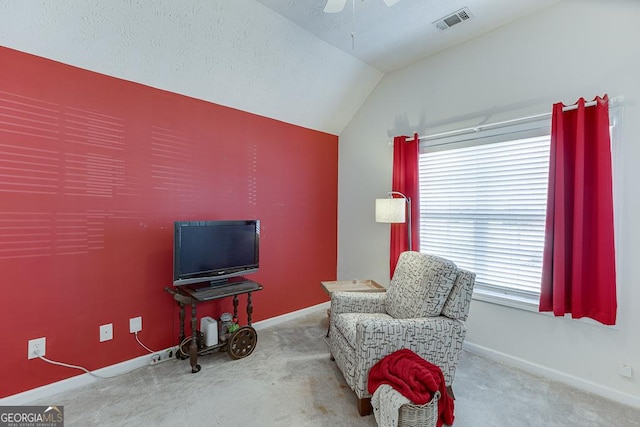 sitting room with carpet flooring, a textured ceiling, vaulted ceiling, and ceiling fan