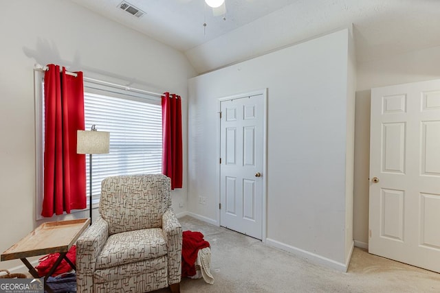 living area featuring ceiling fan, lofted ceiling, and light carpet