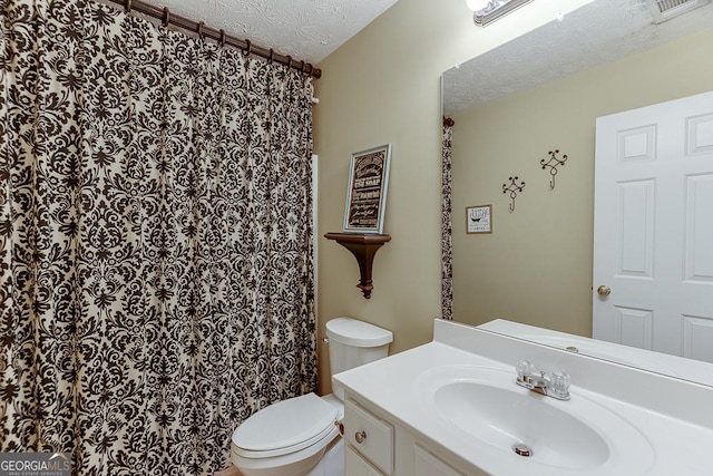 bathroom with vanity, toilet, and a textured ceiling