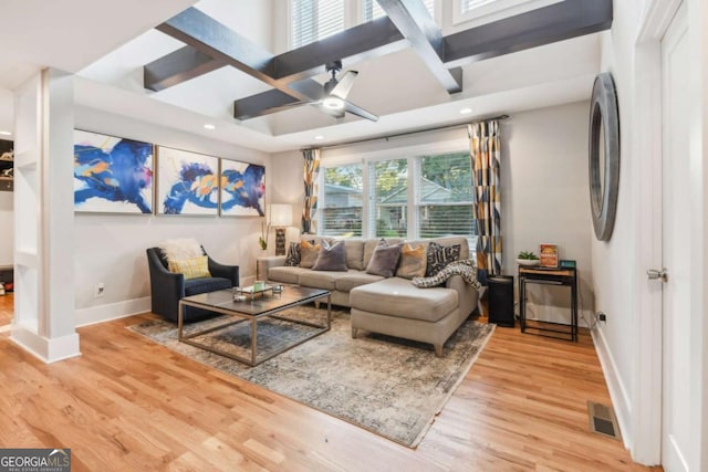 living room with coffered ceiling, ceiling fan, a healthy amount of sunlight, and light hardwood / wood-style flooring