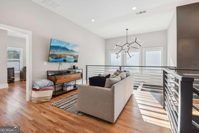 living room with an inviting chandelier and light wood-type flooring