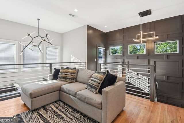 living room featuring a notable chandelier and light wood-type flooring