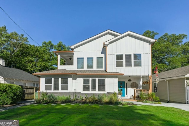 view of front of property with ceiling fan and a front lawn