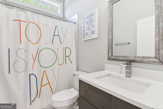 bathroom featuring curtained shower, vanity, and toilet