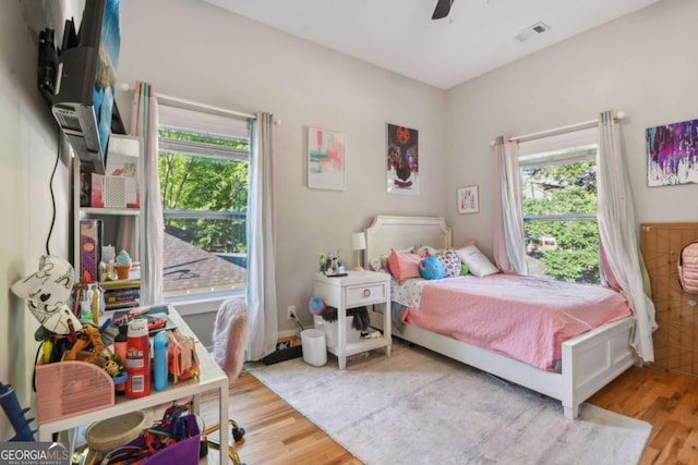 bedroom featuring multiple windows, ceiling fan, and hardwood / wood-style floors