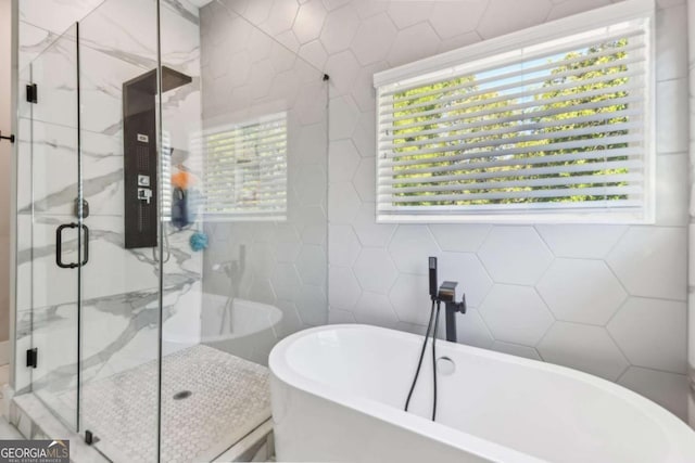 bathroom featuring tile walls and plus walk in shower