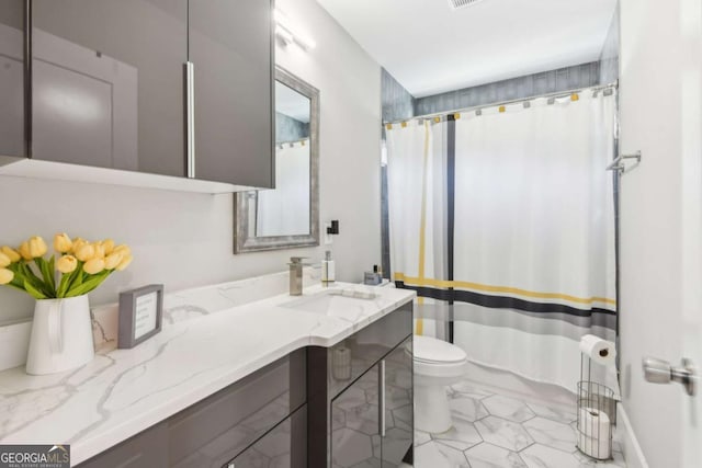 bathroom with tile patterned flooring, vanity, and toilet