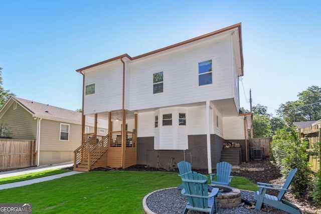 back of house featuring a yard and an outdoor fire pit