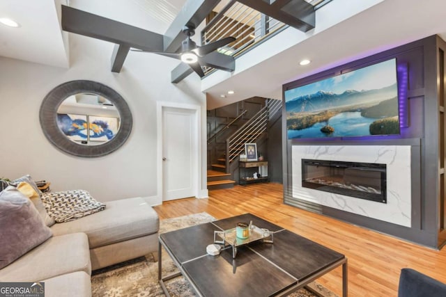 living room with hardwood / wood-style floors, ceiling fan, and a premium fireplace