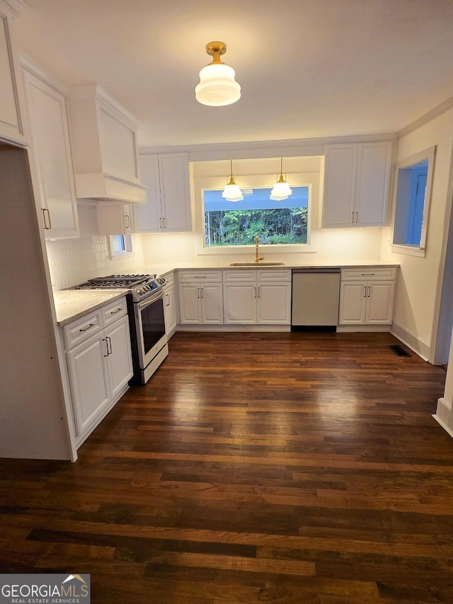 kitchen featuring white cabinetry, sink, stainless steel appliances, light stone counters, and dark hardwood / wood-style floors