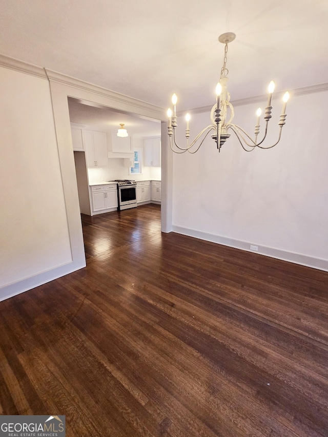 unfurnished dining area featuring dark hardwood / wood-style floors, an inviting chandelier, and crown molding