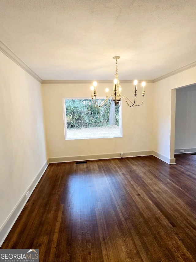 unfurnished dining area featuring dark hardwood / wood-style floors, ornamental molding, a textured ceiling, and an inviting chandelier