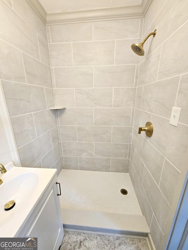 bathroom with a tile shower and vanity