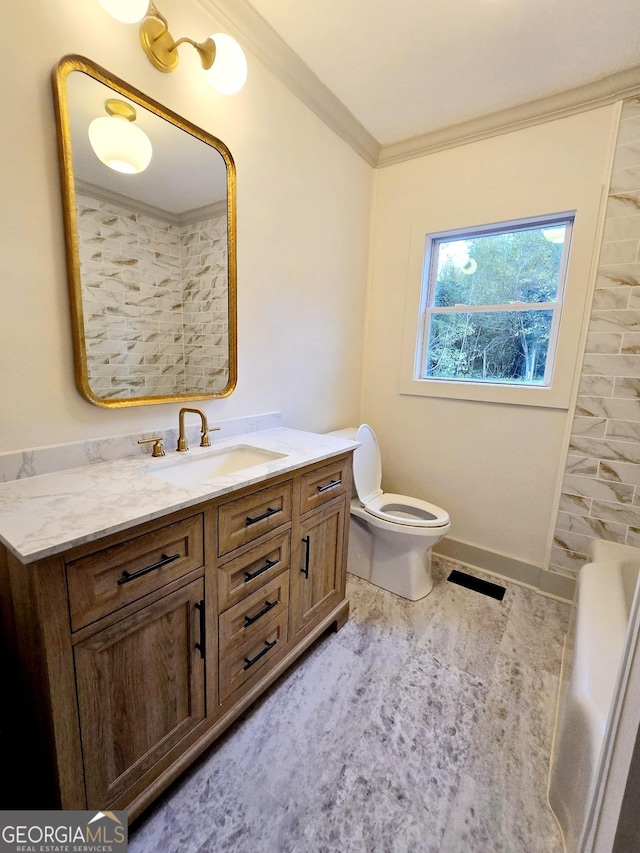 bathroom with vanity, toilet, and crown molding