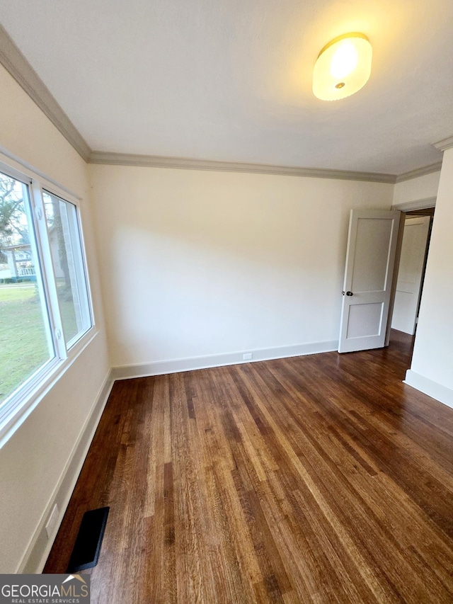 spare room with crown molding and dark hardwood / wood-style floors