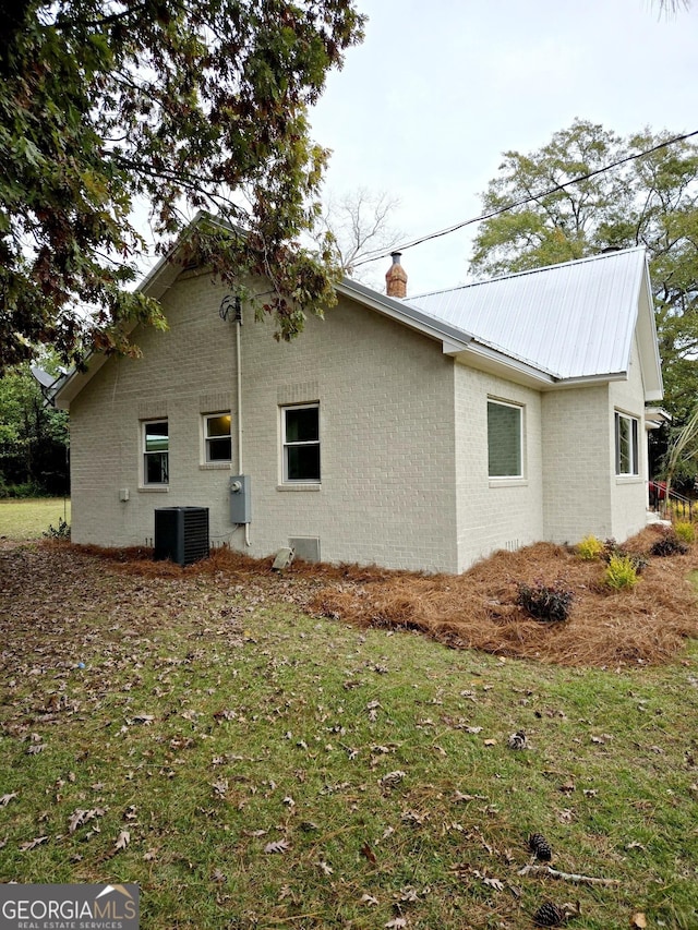 view of side of property featuring a yard and central air condition unit