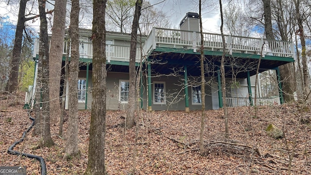 back of house featuring a chimney and a deck