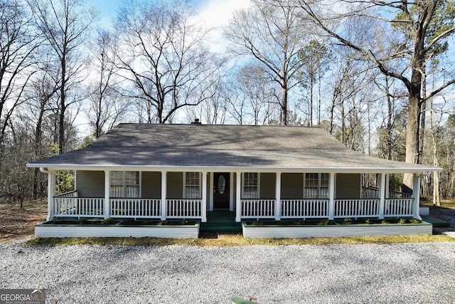 farmhouse inspired home with covered porch, a chimney, and roof with shingles