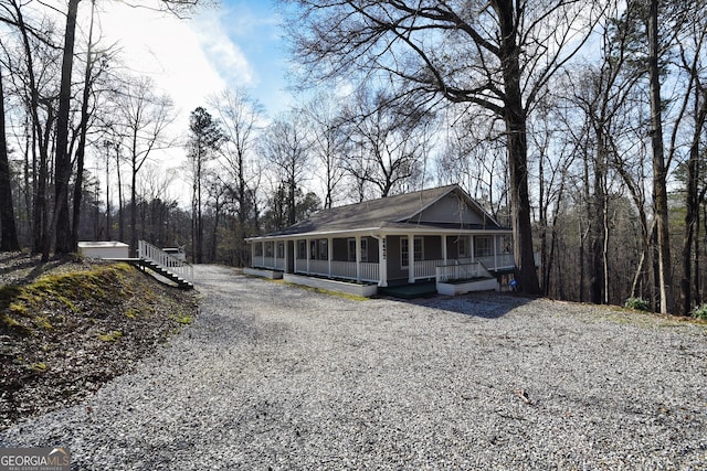 view of front of house featuring gravel driveway and a porch